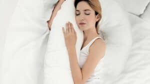 Photo of woman lying on side with arm supported by pillow