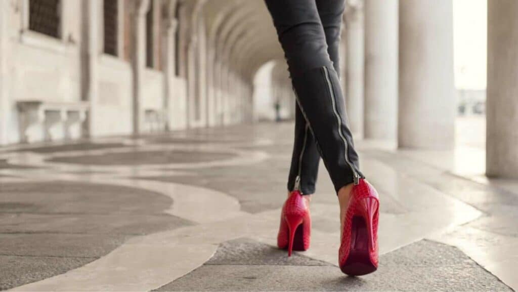 Picture of a person walking in red high heel shoes